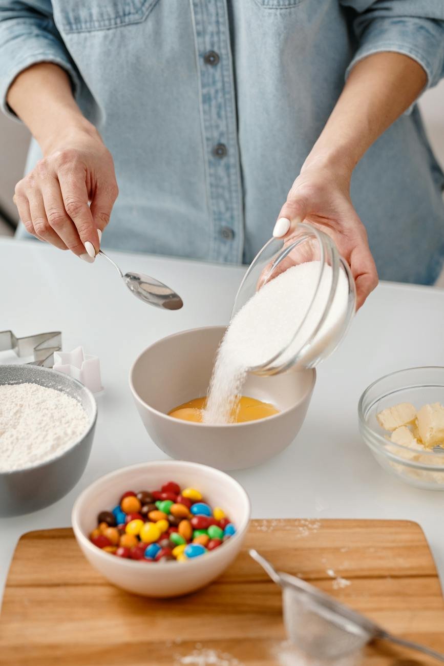 person pouring powdered sugar in a bowl