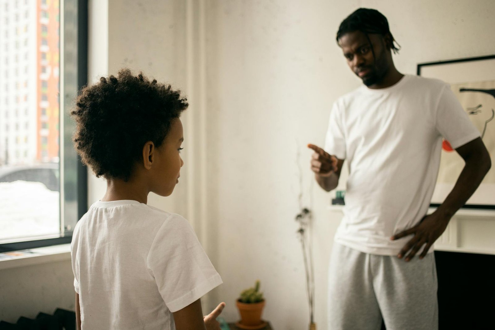 young black father edifying calm son at home